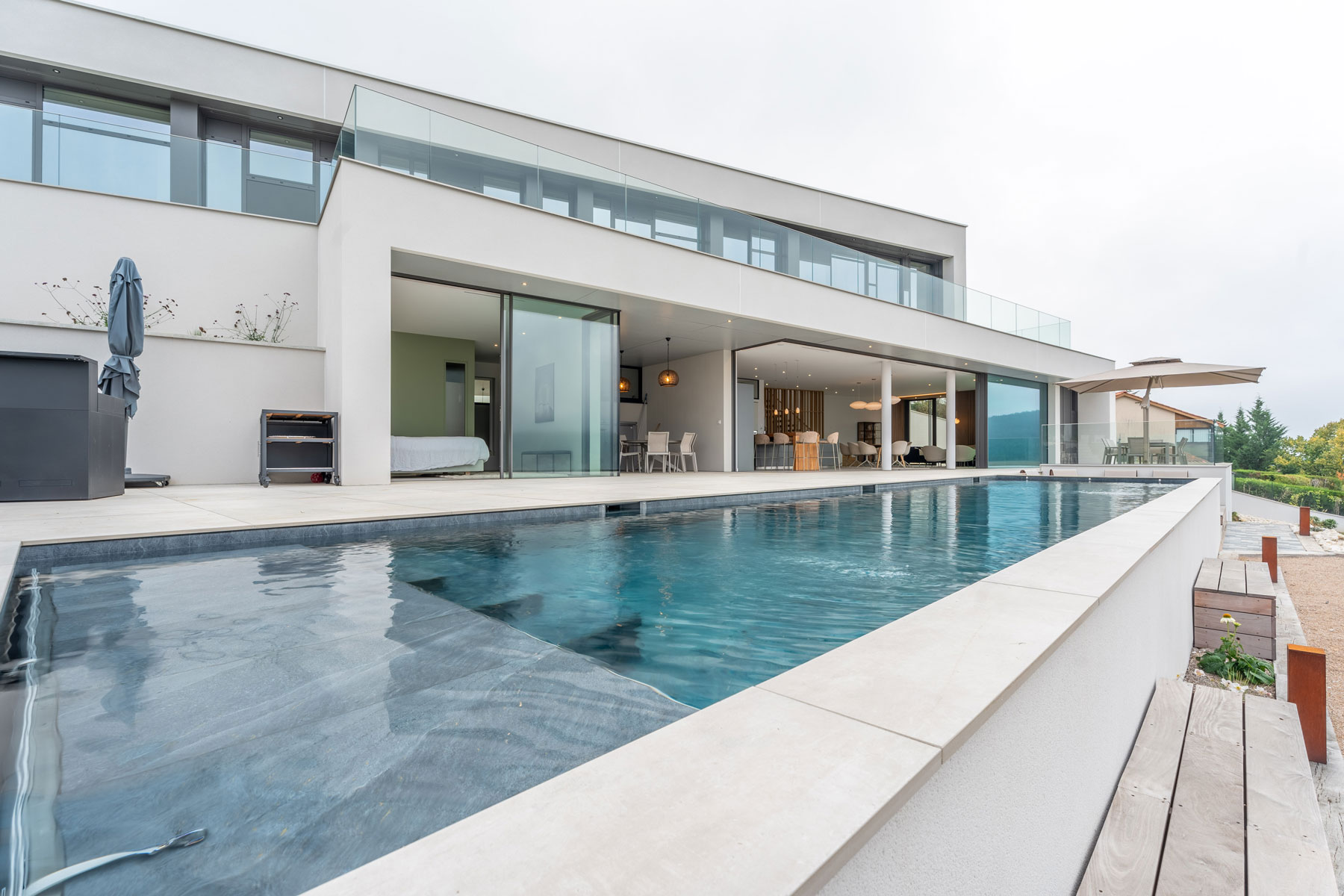 Vue extérieure d'une villa contemporaine avec piscine, située dans les Monts du Lyonnais, et conçue par Ocube Architecture